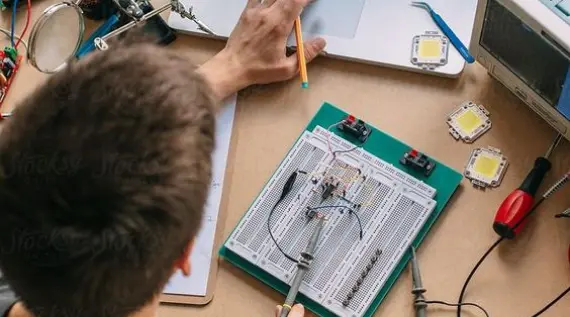 Joven analizando circuito electrónico